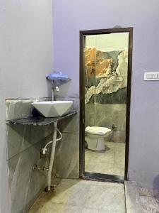 a bathroom with a sink and a toilet at Omshree hotel in Ujjain