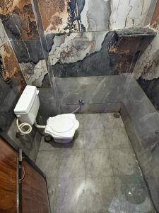 a dirty bathroom with a toilet in a room at Omshree hotel in Ujjain