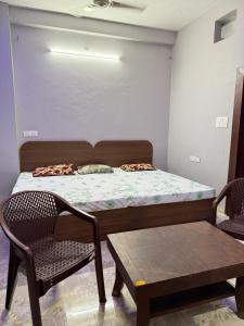 a bedroom with a bed and two chairs and a table at Omshree hotel in Ujjain