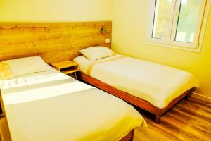 a bedroom with two beds and a window at Lebanon Hostel in Makhāḑat Nahr al Kalb