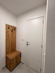 a hallway with a white door and a wooden bench at Apartman Krznarić Centar in Županja +16 photos