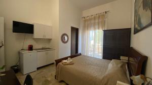 a small bedroom with a bed and a kitchen at Ill Balcone sullo stretto in Reggio di Calabria