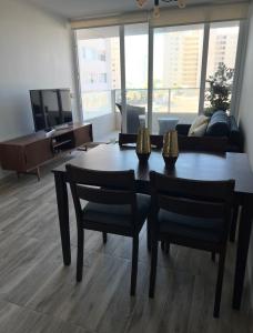 a living room with a table and chairs and a couch at Laguna del Mar, Playa Arrecife in La Serena