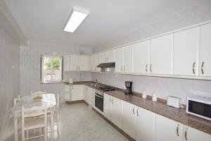 a kitchen with white cabinets and a table in it at Casa Panches, con Vistas al Mar in Panchés