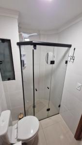 a bathroom with a toilet and a glass shower at Apartamento inteiro in Ponta Grossa +18 photos