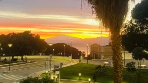 a sunset over a street with a palm tree at Ill Balcone sullo stretto in Reggio di Calabria