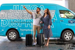 a man and a woman standing in front of a van at Hampton Inn Zacatecas in Zacatecas