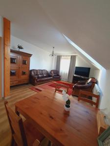 a living room with a wooden table and a couch at Penzion Apartmány Libošovice in Libošovice