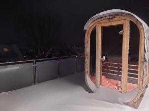 a wooden door on a balcony in the snow at Exklusives Penthouse mit Outdoor Sauna und Whirlpool in Wunschtemperatur in Burgwedel
