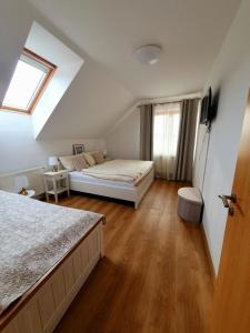 a bedroom with two beds and a window at Penzion Apartmány Libošovice in Libošovice