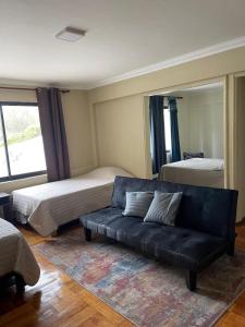 ein Wohnzimmer mit zwei Betten und einer Couch in der Unterkunft El Centrito in Talca