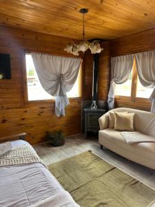 a bedroom with a bed and a couch and windows at Mini Inca Roca in Uspallata +20 photos
