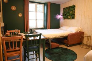 a room with a bed and a table and chairs at Le Studio Vert in La Flèche