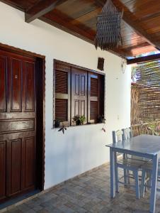 a dining room with a table and a wooden door at Pousada Brisa Del Mar in Icaraí