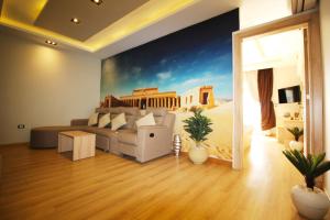 a living room with a couch and a painting on the wall at Palm Pyramids View INN in Cairo