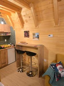 a kitchen with a bar in a room with wooden walls at Vikendica Villa Marija Pale in Pale