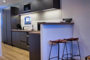 a kitchen with a counter and two stools at Ferienhaus Noa in Twist