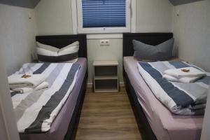 two beds in a small room with a window at Ferienhaus Noa in Twist