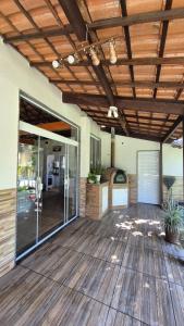 an outdoor deck with a wooden ceiling and glass doors at Sítio no Rio de Janeiro, privativo, Natureza, conforto e lazer em Nova Iguaçu, RJ in Nova Iguaçu