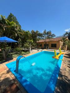a swimming pool with a slide in a yard at Sítio no Rio de Janeiro, privativo, Natureza, conforto e lazer em Nova Iguaçu, RJ in Nova Iguaçu