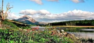 a person in a boat on a river with a mountain at Teach Hudi Beag, Bar & Accommodation Bunbeg in Bunbeg