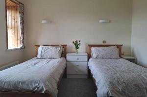 two beds sitting next to each other in a bedroom at Teach Hudi Beag, Bar & Accommodation Bunbeg in Bunbeg