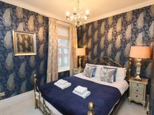a bedroom with a bed and a chandelier at Rutland Grange in Filey