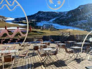 a bunch of tables and chairs on a deck at Le cosy d Asmae in Ustou
