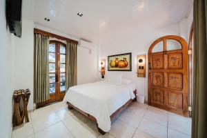 a white bedroom with a bed and a window at Hotel Villabosque Eco Boutique in Manuel Antonio +74 photos