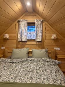 a bed in a room with a window at Osada na Skale Domek z kominkiem in Istebna