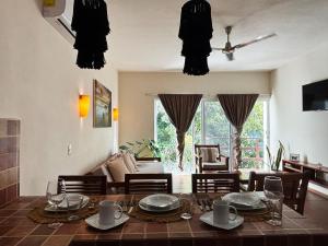 a living room with a table and chairs and a dining room at Tulum Nah in Tulum