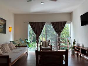 a living room with a table and a large window at Tulum Nah in Tulum