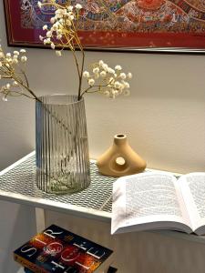 a table with a vase and a book on a shelf at Expo Śniadeckich in Poznań