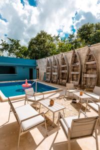 a patio with chairs and a pool and a building at Alma de Zorro in Bacalar