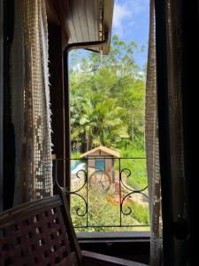 a window of a room with a view of a garden at Pousada na Cervejaria Altezza - vista para Pedra Azul in Venda Nova do Imigrante