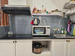 a kitchen counter with a microwave and a sink at LoCo Fully Equipped House - 2BR3WS in Ho Chi Minh City
