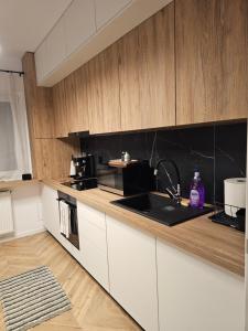 a kitchen with white cabinets and a black counter top at Urusagului flat in Floreşti +8 photos