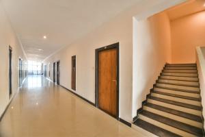 a hallway with stairs and a wooden door at Capital O Amit Palace in Bhilwara