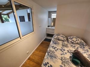 a small bedroom with a bed and a window at Contain'House Paradise in Les Abymes