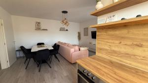 a living room with a table and a pink couch at Apartman Vrućica view in Teslić +21 photos