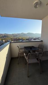 a balcony with a table and chairs and a view at Apartman Vrućica view in Teslić