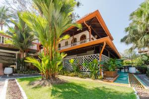 a house with a palm tree in front of it at Hotel Villabosque Eco Boutique in Manuel Antonio