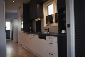 a kitchen with white cabinets and a sink at Ferienhaus Aurora in Twist