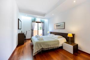 a bedroom with a bed and a table with a lamp at Luz Beach Luxury Apartment in Luz