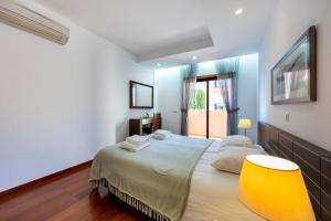 a bedroom with a large bed with a yellow chair at Luz Beach Luxury Apartment in Luz