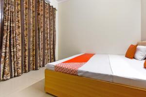 a bedroom with a bed and a curtain at Hotel O Sabtera Homes in Kharar