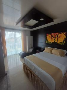 a bedroom with a large bed and a large window at HOTEL DULCES SUEÑOS in Buenaventura