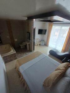 a bedroom with a large bed and a television at HOTEL DULCES SUEÑOS in Buenaventura