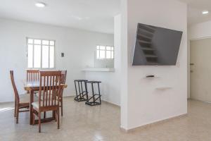 a living room with a table and a flat screen tv at Casa completa con alberca en Chetumal in Chetumal