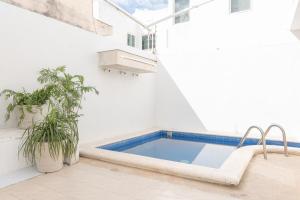 a swimming pool in the middle of a white room with at Casa completa con alberca en Chetumal in Chetumal